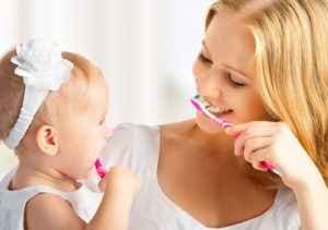 mom and daughter teaching oral hygiene